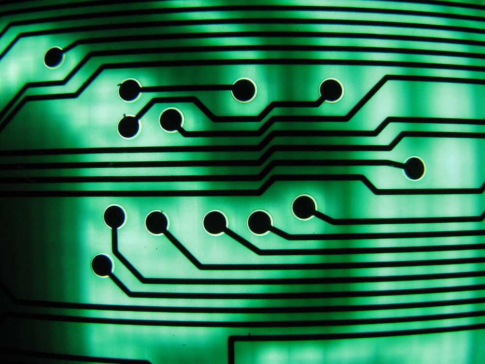 Close-up of green circuit board traces lit from behind